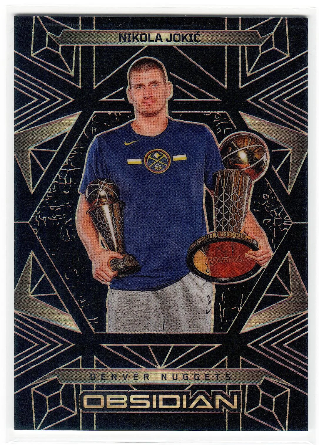 2024-25 Panini Obsidian #184 — Nikola Jokić holding the Larry O'Brien championship trophy and the Bill Russell Finals MVP trophy